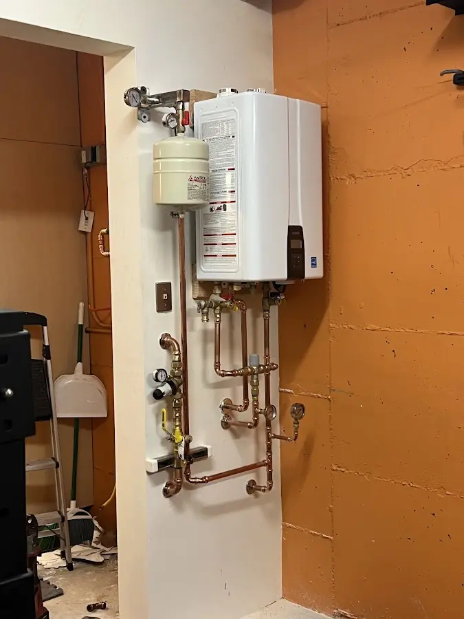 Plumbing technician inspecting water heater connections in Walbridge